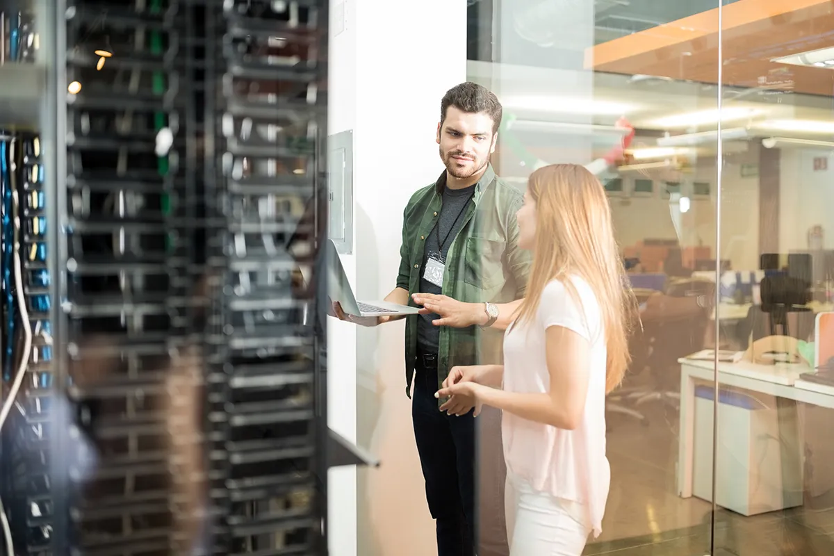 two business people standing server room with laptop discussing Kopie